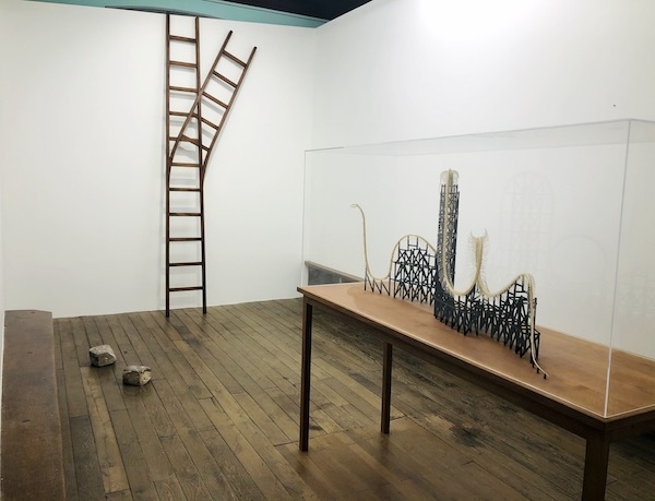 vue de l'exposition avec une echelle en forme de rail de train.