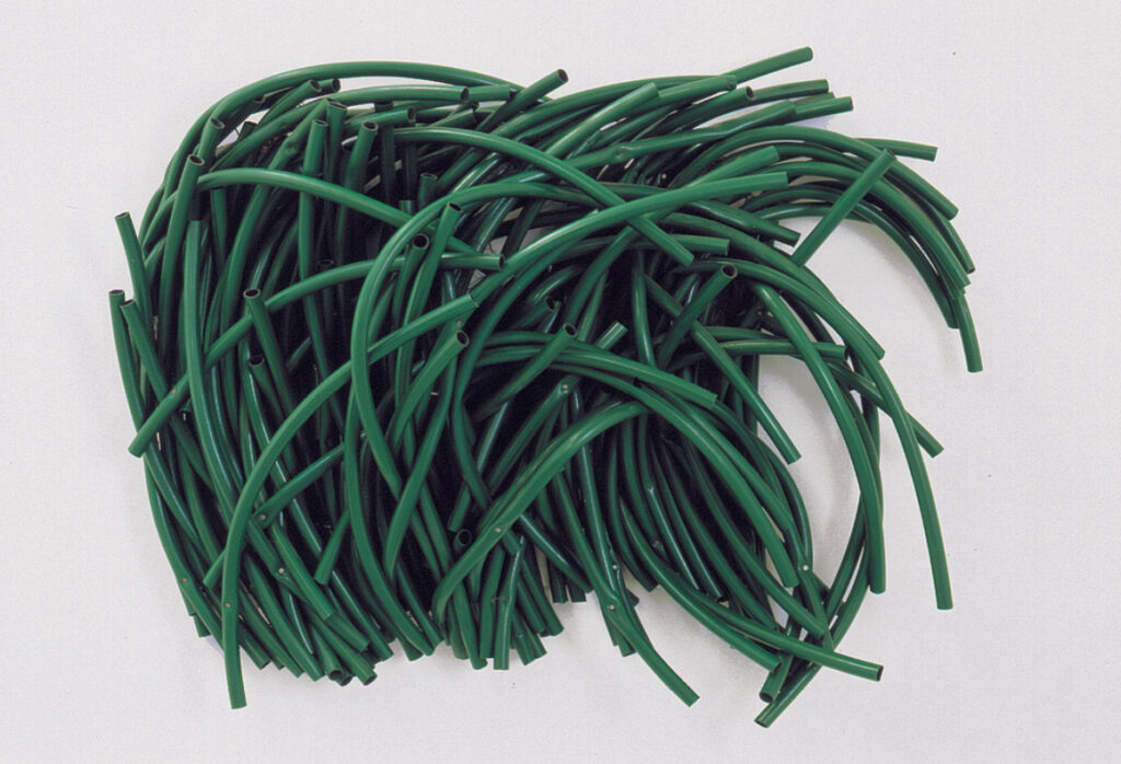 Sculpture d'une Touffe d'herbes faite avec les tube en plastique vert.
