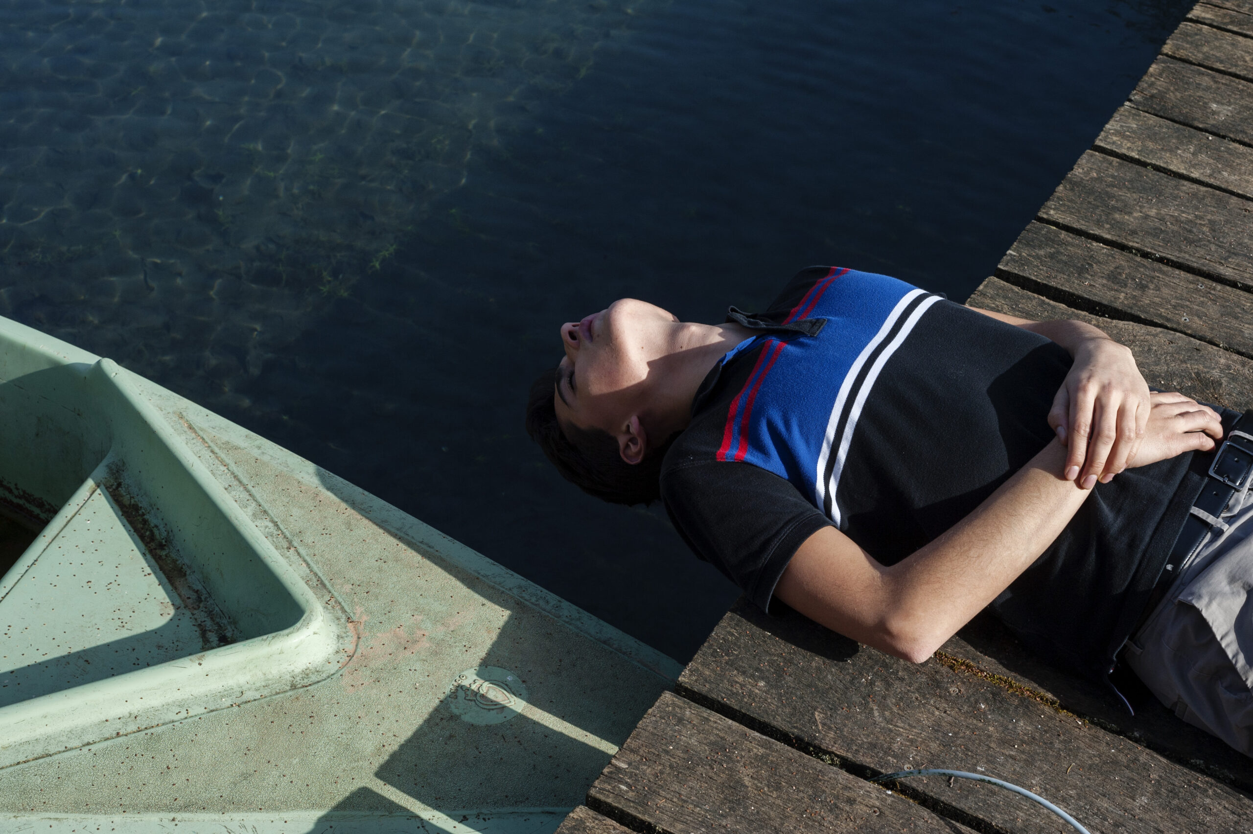 Photo d'un jeune homme endormi près de l'eau