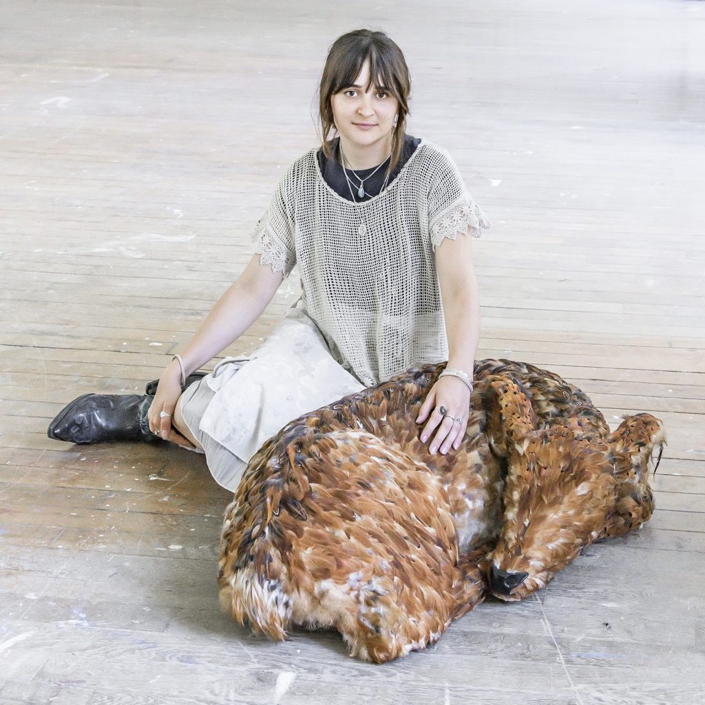 Portrait de l'artiste assise à côté de sa sculpture Marguerite