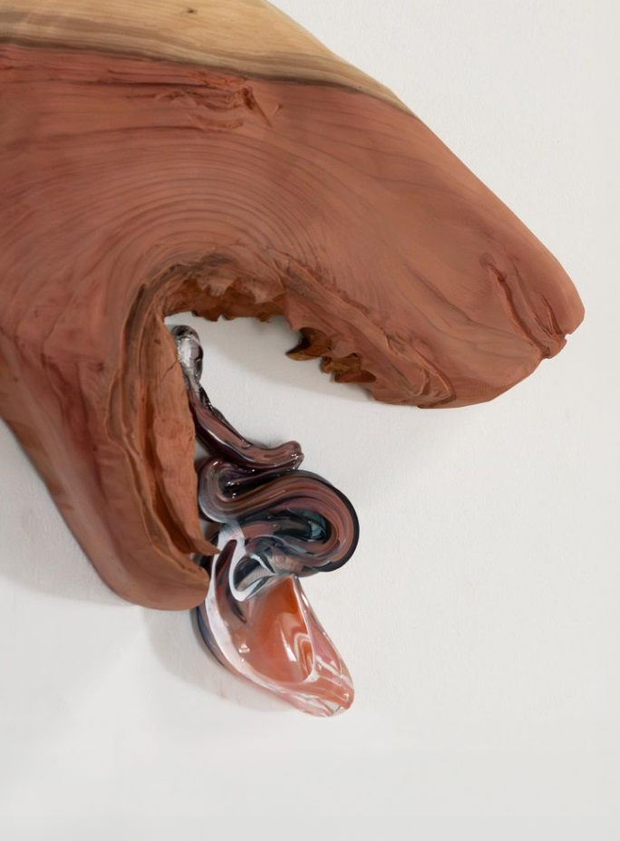 Image d'un museau de chien sculpter, en bois et sa langue pendue, façonnée avec du verre rouge et transparent