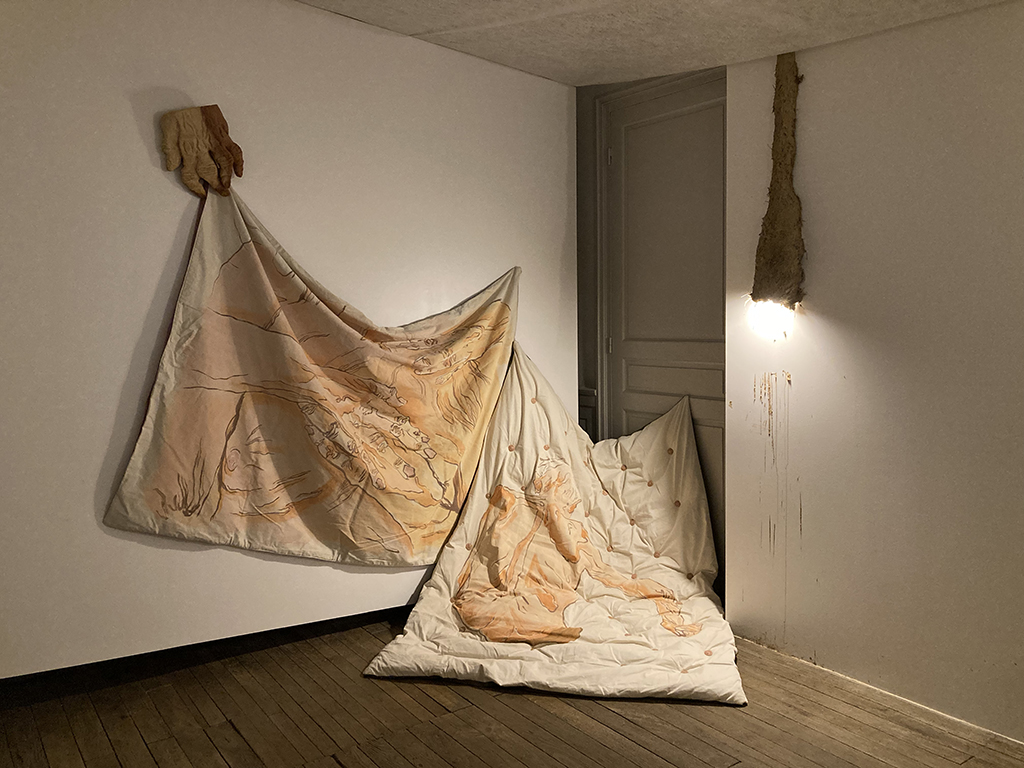 Une couverture et un matelat sur lesquels sont dessinés des corps de personnes âgées