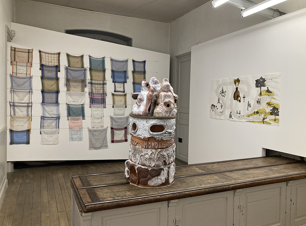Vue de l'exposition avec une sculpture de en céramique et trois dessin au mur de Marie Follea et au fond une installation de mouchoirs en tissus de Damien Rouxel.