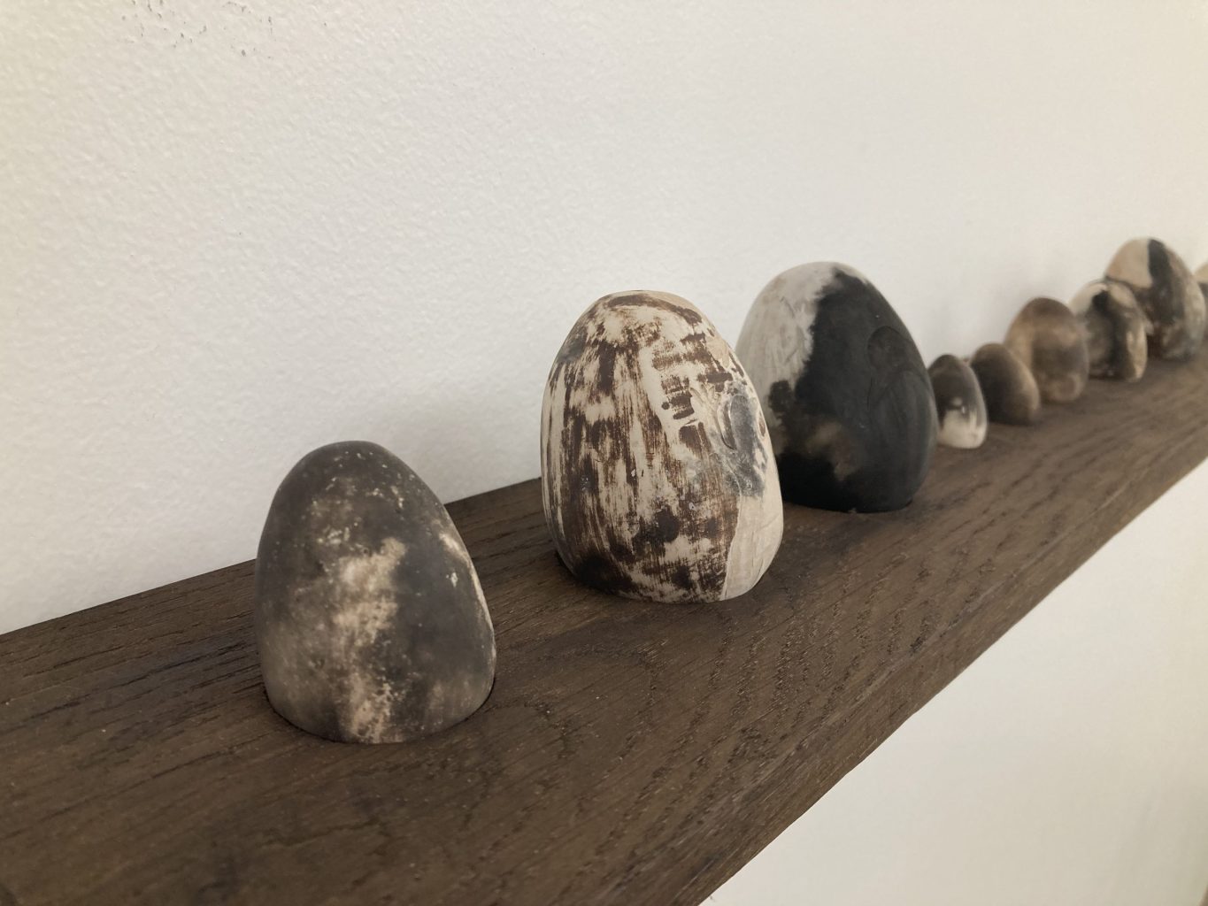 Oeufs en grès noir et blanc sur une étagère en bois